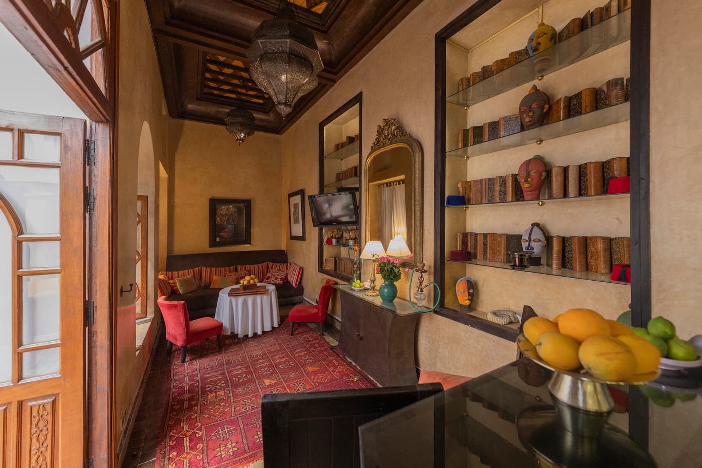 Le bar-bibliothèque du riad : tadelakt ocre, laiton, masques et kilim rouge